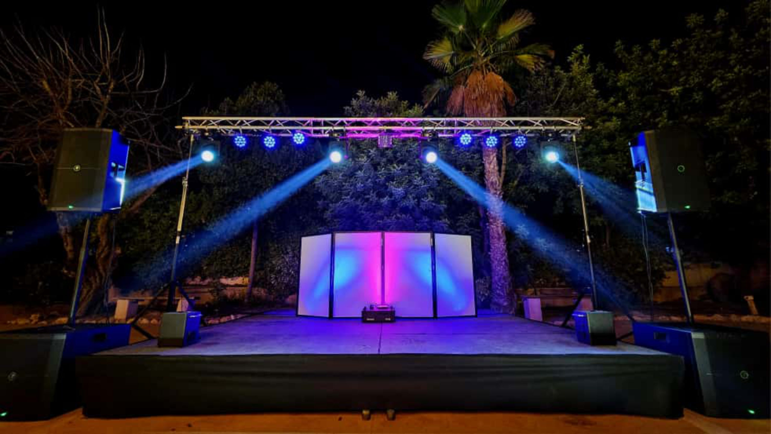 Escenario con setup para DJ, PA y puente de luces